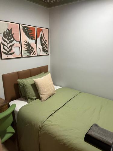 a bedroom with a bed with green sheets and pillows at CityNest Hotel in New York