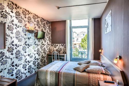 a bedroom with a bed and a window at Le Terminus in Villeneuve-sur-Lot