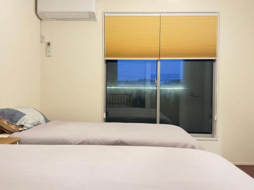 a bedroom with a bed and a large window at The Maruko in Abiko