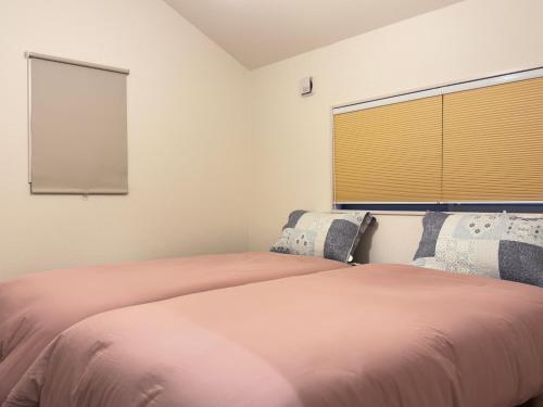 a bedroom with a large bed with a window at The Maruko in Abiko