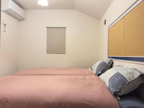 a bedroom with two beds and a window at The Maruko in Abiko