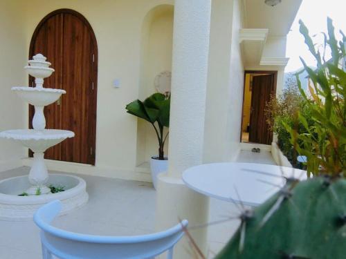 a bathroom with a fountain in a room with plants at Le Cosmos Vĩnh Hy in Vĩnh Hy