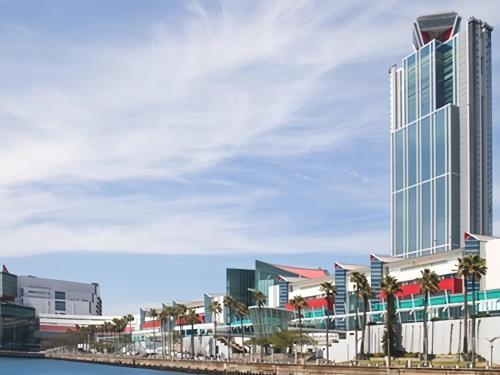 a view of a city with palm trees and a building at LiVEMAX Sakishima Cosmo Tower Hotel in Osaka
