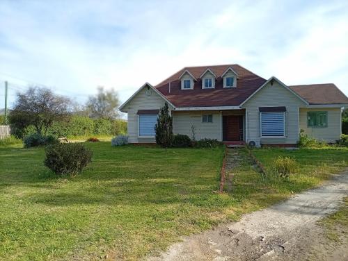 a white house with a brown roof on a yard at Parcela en Mallarauco in Melipilla