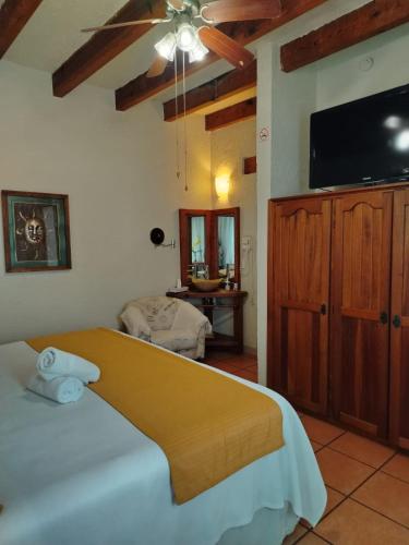 a bedroom with a bed and a flat screen tv at Casa d'Lobo Hotel Boutique in Malinalco
