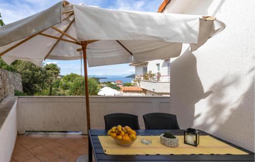 a table with an umbrella and a bowl of fruit at Nice Home In Supetarska Draga With Wifi in Supetarska Draga