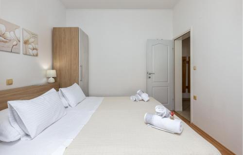 a bedroom with a large white bed with towels on it at Nice Home In Supetarska Draga With Wifi in Supetarska Draga