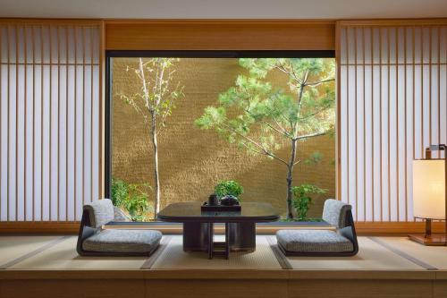 a room with a table and chairs and a large window at Dusit Thani Kyoto in Kyoto