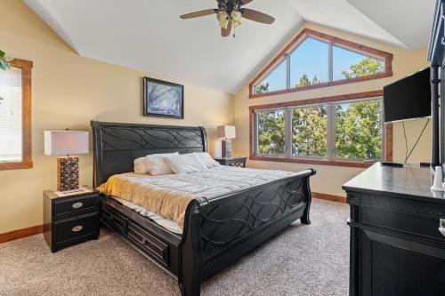 a bedroom with a black bed and a window at Sleep 12-big Sandy Lodge V10-lakefront-luxury in McGregor