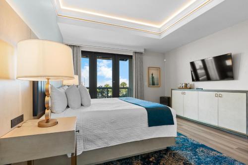 a bedroom with a bed and a large window at Harbor Suites at Harborwalk Village in Destin