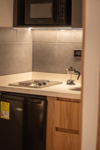 a kitchen with a stove and a microwave at Autenthico Local Stay Hotel Envigado in Envigado