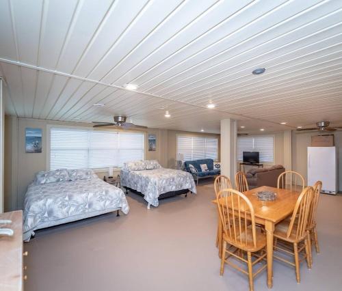 a bedroom with two beds and a table and chairs at Lakeside Living Paradise in Zwolle