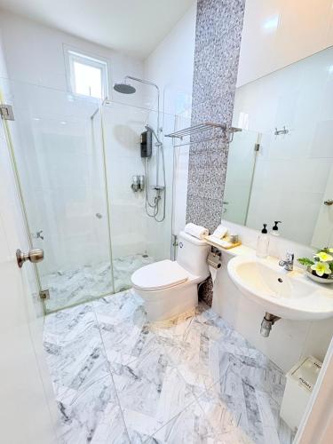 a bathroom with a shower and a toilet and a sink at Townhome Sattahip in Sattahip