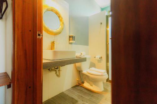 a bathroom with a sink and a toilet and a mirror at Hotel Maria Maria in Bacalar