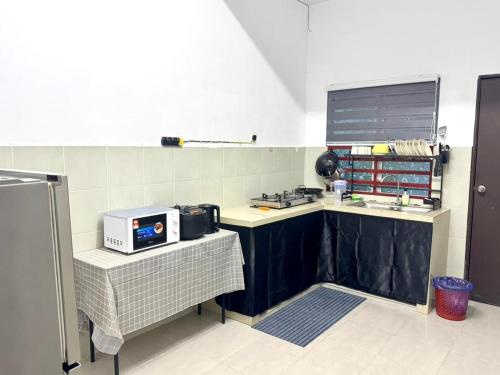 a kitchen with a counter with a microwave on it at Salak Lestari Homestay Klia Klia2 in Sepang