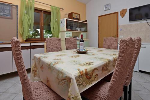 una mesa de comedor con una botella de vino. en Family friendly house with a swimming pool Dolenja Vas, Central Istria - Sredisnja Istra - 24528, en Dolenja Vas