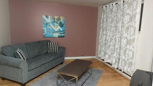 a living room with a couch and a table at Spacious and comfortable accommodation in Longueuil