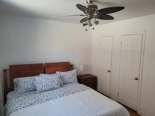 a bedroom with a bed with a ceiling fan at Spacious and comfortable accommodation in Longueuil