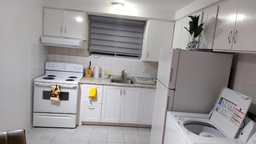 a kitchen with a white refrigerator and a sink at Spacious and comfortable accommodation in Longueuil