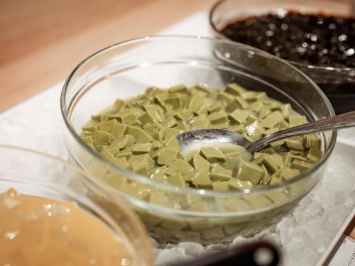 a bowl of green food with a spoon in it at Kinugawa Hotel Mikazuki in Nikko