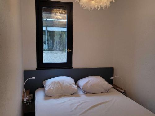 - 2 oreillers sur un lit dans une chambre avec fenêtre dans l'établissement Studio cosy 4/5 pers, pied des pistes, balcon exposé ouest - FR-1-458-253, au Chinaillon