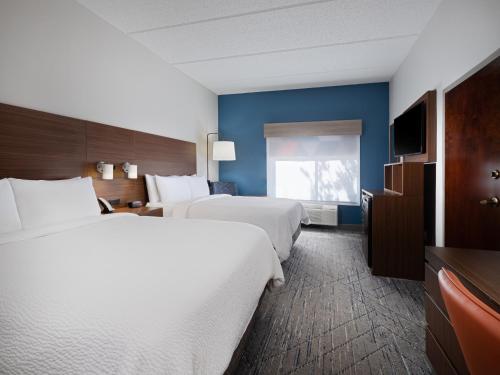 a hotel room with two beds and a television at Holiday Inn Express & Suites Augusta West - Ft Gordon Area by IHG in Augusta