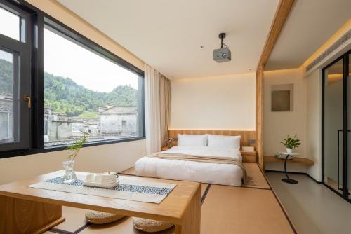 Ένα ή περισσότερα κρεβάτια σε δωμάτιο στο Floral Hotel Xidi Jiuheboshe B&B