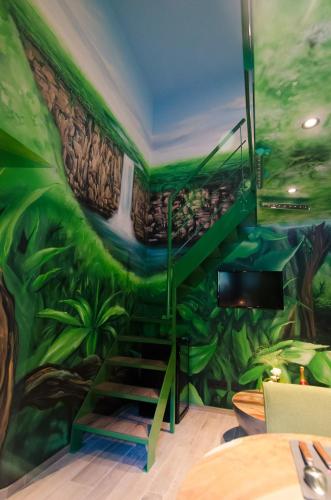 a room with a green jungle mural on the wall at River Lodge Hotel Insolite in Maredsous