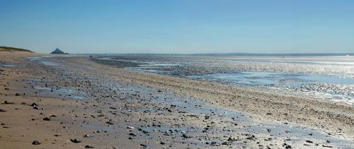 a beach with a lot of rocks and water at ibis budget Granville in Granville