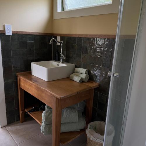 a bathroom with a sink on a wooden table at Wisteria Way in Opononi