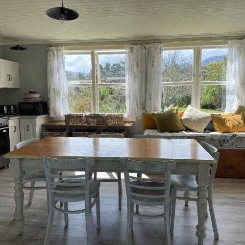 a living room with a table and chairs and a couch at Wisteria Way in Opononi