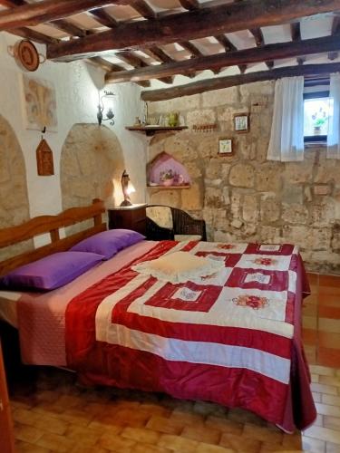 a bedroom with a bed and a stone wall at B&B Bellavista in Bagnoregio
