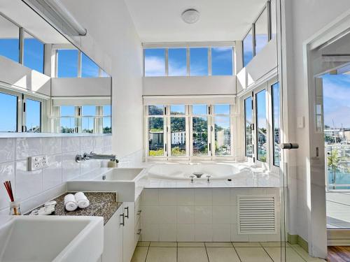 a bathroom with a large tub and a large window at Beachside 17 in Nelly Bay