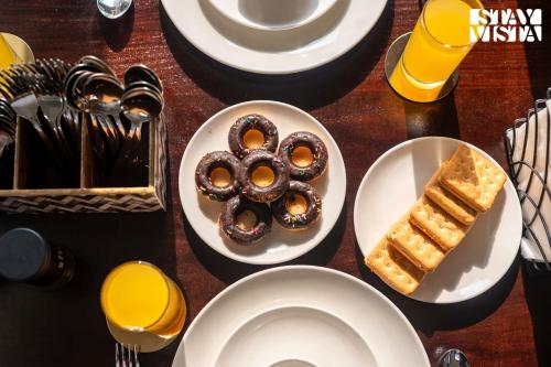 a table with plates of pastries and utensils at StayVista at Mizu Retreat with Pool & Terrace in Karjat