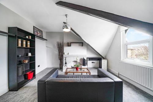 a living room with a couch and a table at Charming Designer Cosy Loft Apartment in London