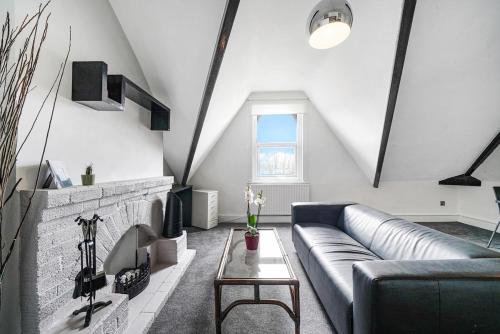 a living room with a couch and a brick wall at Charming Designer Cosy Loft Apartment in London