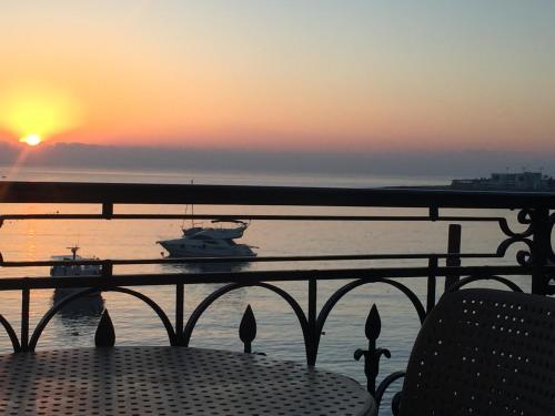 a table with a view of the ocean at sunset at Maltese Balcony in St Julian's