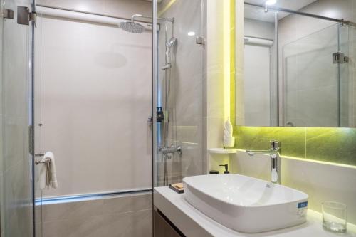 a bathroom with a sink and a glass shower at Mandala Hotel & Suites Hải Dương in Bảo Thap
