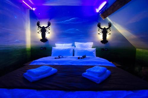 a bedroom with a bed with two antlers on the wall at River Lodge Hotel Insolite in Maredsous