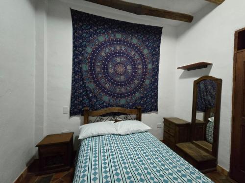 una camera da letto con un letto con arazzo appeso al muro di IL CASTELLO DI LETTERE Barichara a Barichara