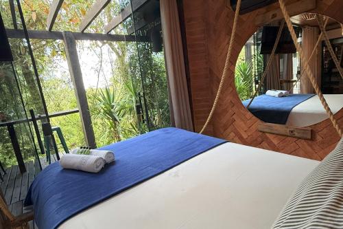 two beds in a room with a window at Casa Container 80 in Campos do Jordão