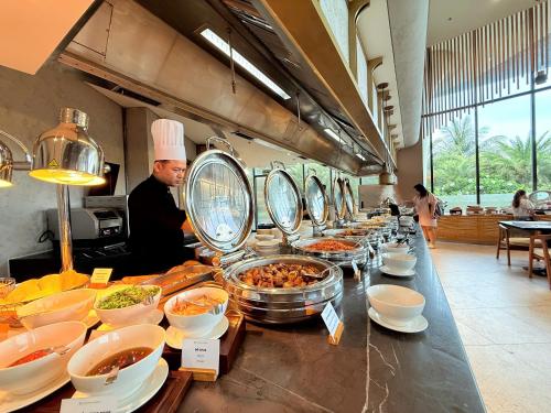een chef-kok in een keuken met een buffet met eten bij Villa Beachfront in Cam Lâm