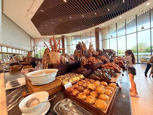 een vrouw die voor een voorstelling van eten staat bij Villa Beachfront in Cam Lâm