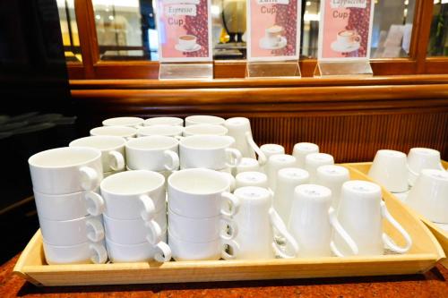 een dienblad met witte bekers op een tafel bij FuramaXclusive Pratunam Park Hotel in Bangkok