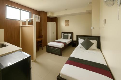 a hotel room with two beds and a sink at Home Stay Hotel in Canelar