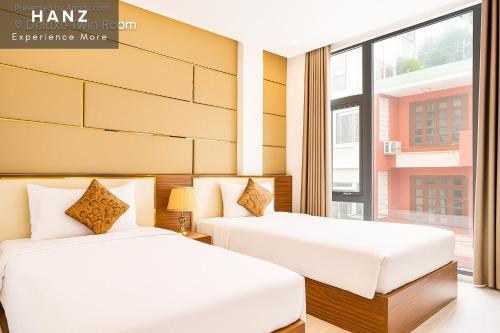 two beds in a room with a window at S79 My My Hotel in Ho Chi Minh City