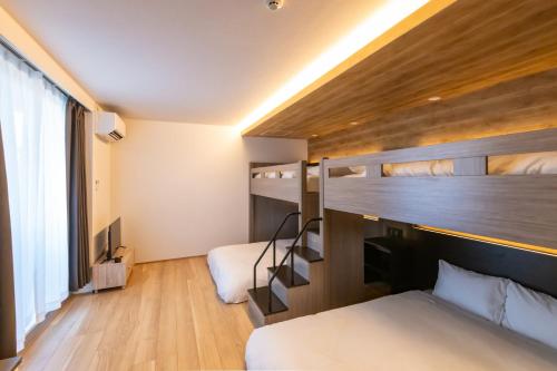 a bedroom with two bunk beds and a staircase at ReLA 柏駅北 in Kashiwa