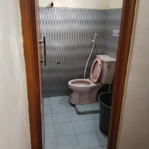 a bathroom with a pink toilet in a stall at Ayna Guest House Syariah Indramayu in Kepandean