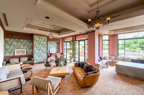 a living room with couches and tables and windows at Ooedo Onsen Monogatari Premium Saikaibashi in Sasebo
