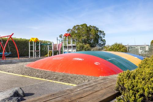 a park with a playground with a colorful play structure at Kaikōura TOP 10 Holiday Park in Kaikoura